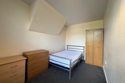 Bright, simply furnished bedroom with a metal d...