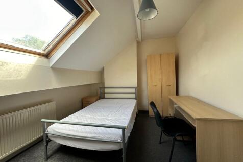 Bright attic single bedroom with a large skylig...