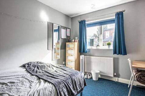 Bright, tidy bedroom with a large window, blue ...