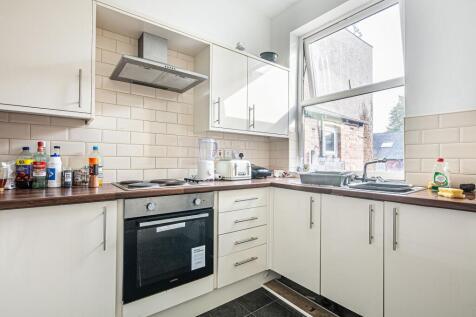 Bright galley-style kitchen with white cabinetr...