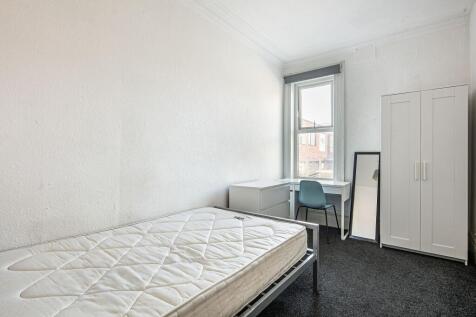 Bright, simply furnished single bedroom with a ...