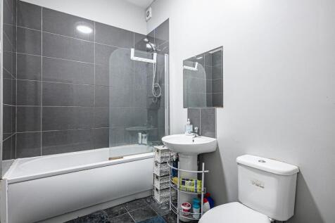 Modern bathroom with a bathtub and overhead sho...