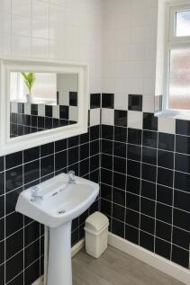 Stylish tiled bathroom with contrasting black-a...