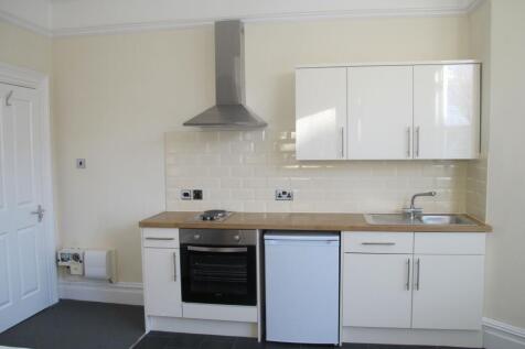 Bright, modern fitted kitchenette with white gl...