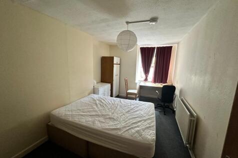 Bright, simply furnished bedroom featuring a do...