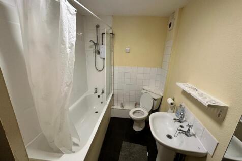 Compact bathroom with a bathtub and shower, ped...