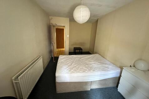 Bright, simply furnished bedroom with a comfort...