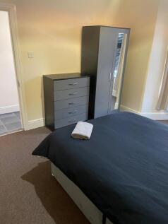 Bright, neatly presented bedroom featuring a do...
