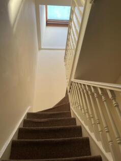 Bright, well-maintained carpeted stairway with ...