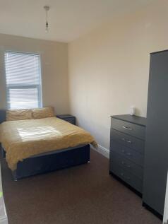 Bright, simply furnished bedroom with a comfort...