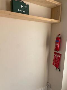 Small tidy storage alcove with wooden shelving,...