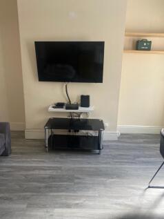 Contemporary living area with a wall-mounted TV...