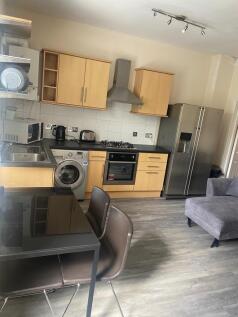 Modern open-plan kitchen with wood-effect cabin...