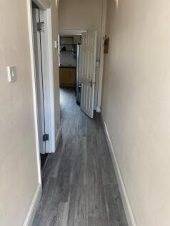 Bright, narrow hallway with modern grey wood-ef...