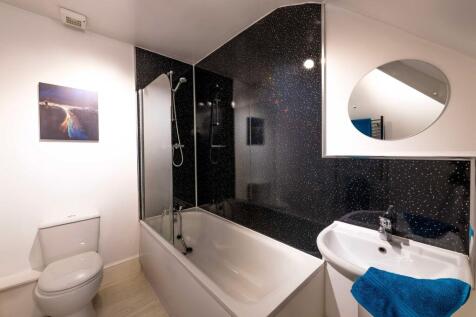 Modern bathroom with a white bathtub and integr...