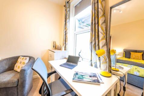 Bright, well-styled bedroom with a large window...