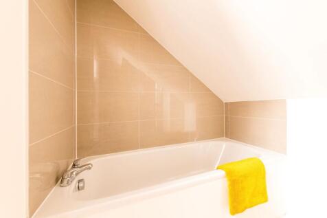 Bright tiled bathroom with a white built-in bat...