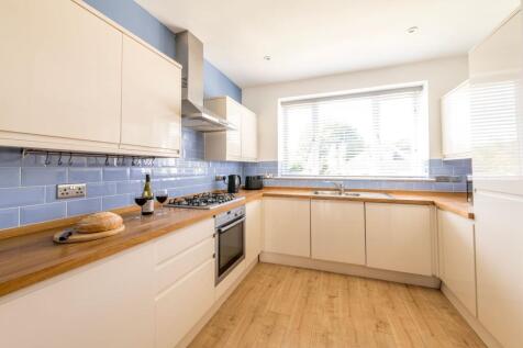Bright modern kitchen with glossy cream cabinet...