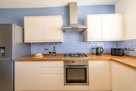 Bright modern kitchen with wooden countertops, ...