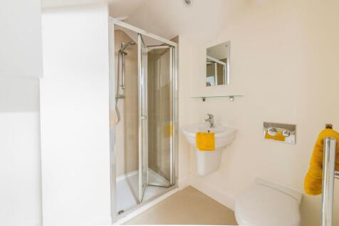 Bright, modern bathroom with a corner shower en...