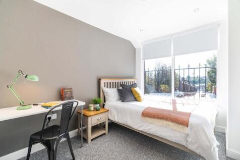 Bright, neatly styled bedroom with a comfortabl...