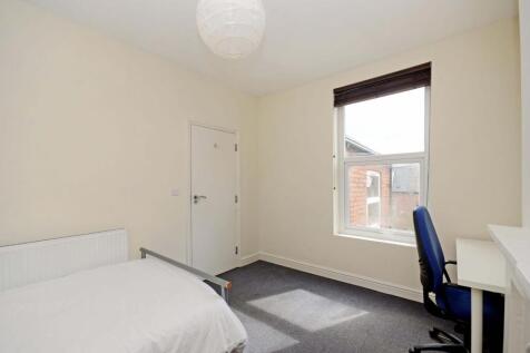 Bright, neutrally decorated bedroom with a larg...