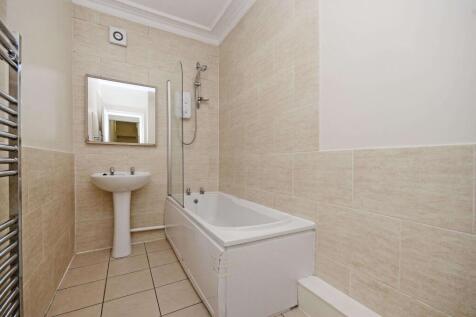 Bright, modern bathroom with tiled walls, a bat...