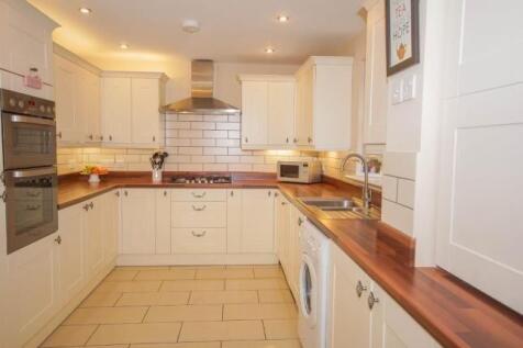 Bright, modern kitchen with cream cabinetry, wa...