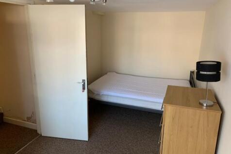 A tidy single bedroom featuring a bed and a dre...