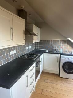 Modern fitted kitchen with dark worktops, integ...