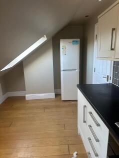 Bright kitchen area with angled skylight, moder...