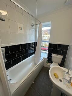 Bright, modern bathroom with a full bathtub and...