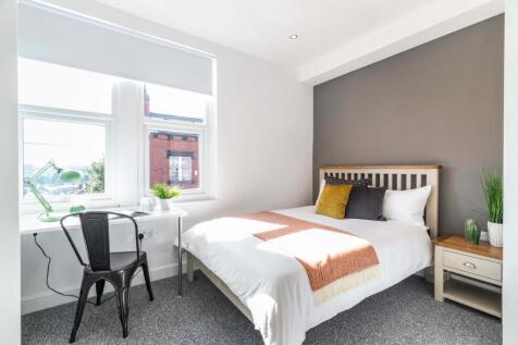 Bright, neatly styled double bedroom with a com...