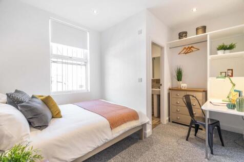 Bright, neatly furnished double bedroom with a ...