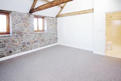 Bright master bedroom with exposed stone wall a...