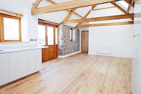 Bright open-plan living area with exposed woode...