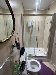 Bright bathroom with a glass-enclosed shower, t...