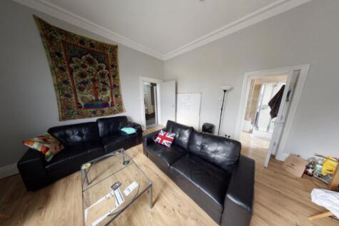 A spacious and well-lit living room featuring a...