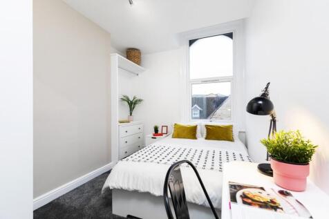 Bright and airy master bedroom featuring a comf...