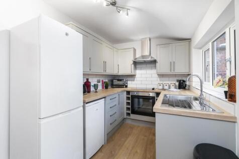 A bright and tidy kitchen with modern white cab...