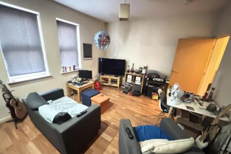 A spacious and well-lit living room featuring c...