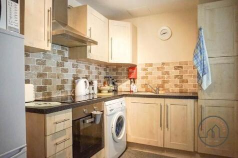 Bright, modern kitchen with integrated oven, ho...