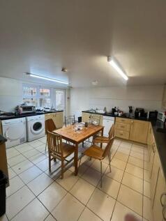Spacious communal kitchen with tiled floors, pl...