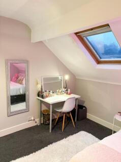 Bright, cozy attic bedroom with angled ceiling ...