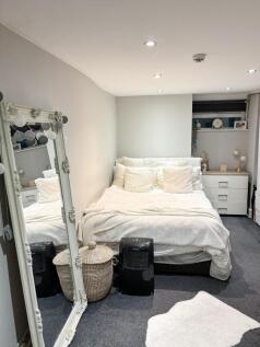 Cozy double bedroom with a neatly made bed, sof...
