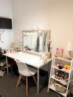 Bright, tidy bedroom desk area with a large mir...