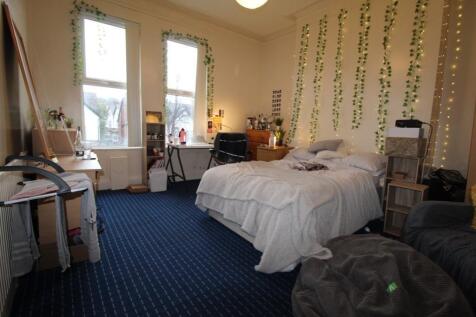 Bright, comfortably furnished bedroom with a do...
