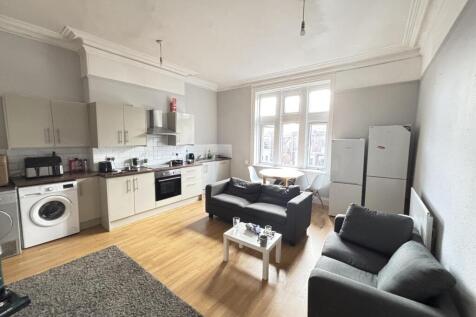 A bright, modern living room featuring large wi...