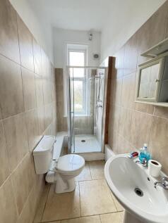 A clean and bright bathroom featuring a toilet,...