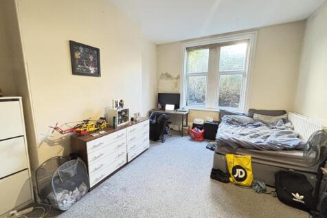 A cozy bedroom featuring a bed with some beddin...